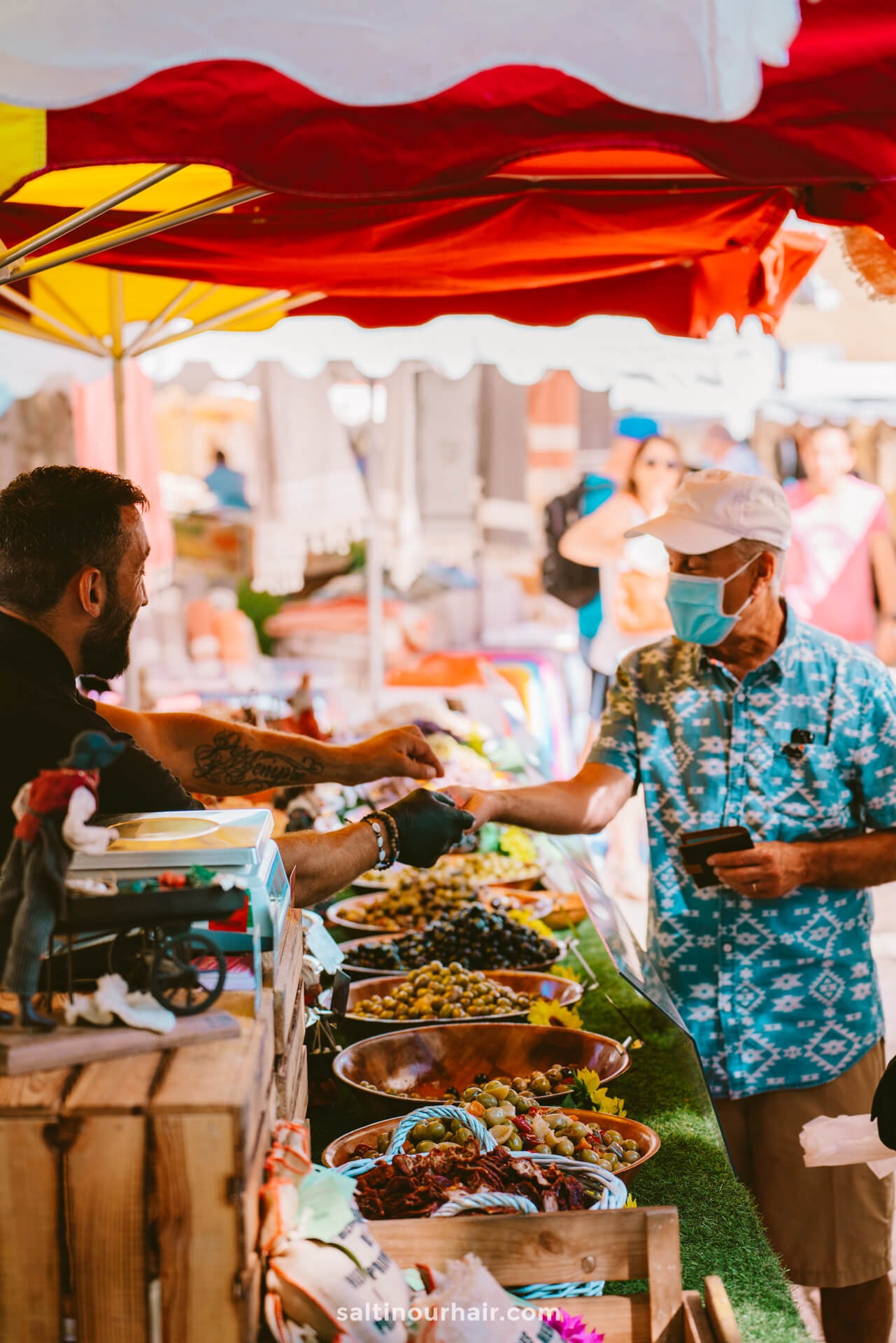 A vendor and a customer greet each other at an outdoor market stall in San Crist&oacute;bal de La Laguna, tenerife