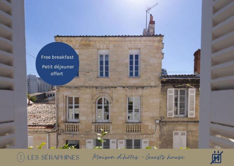 View of a three-story stone BnB with shuttered windows, seen from another building in Bordeaux. Promotional text offers free breakfast. Branding for Les Séraphines Maison d’hôtes – Guests house is visible.