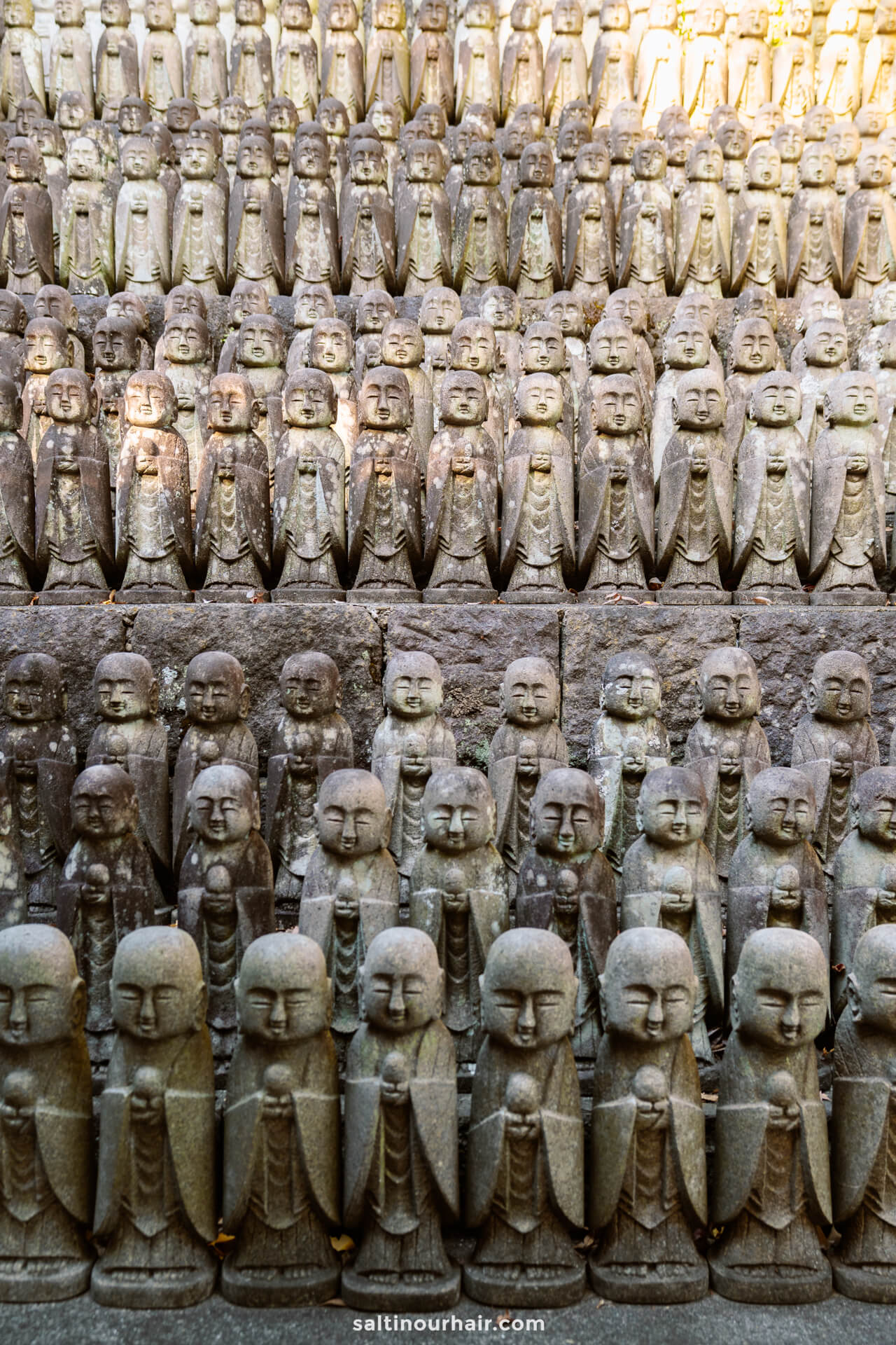 rows of similar statues garden Japan