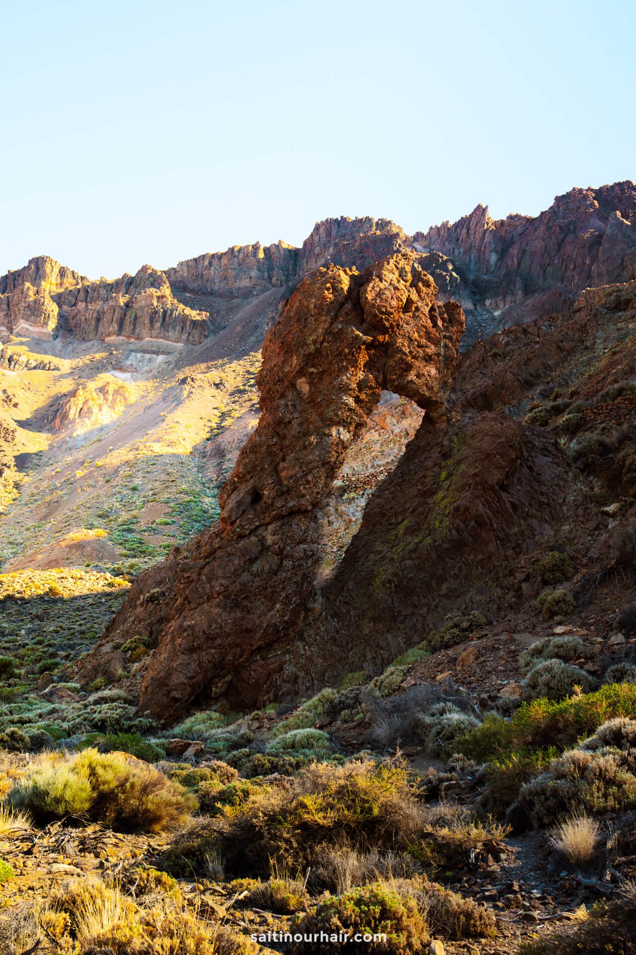 queen shoe rock formation with a natural arch stands, dry vegetation and rocky terrain in Teide National Park