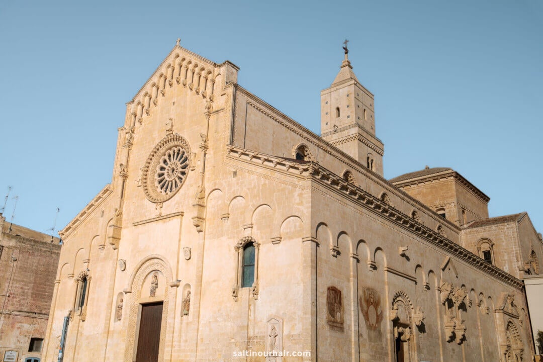 Duomo di Matera, the Cathedral of Matera, with a rose window, arched doorways, and a tall bell tower