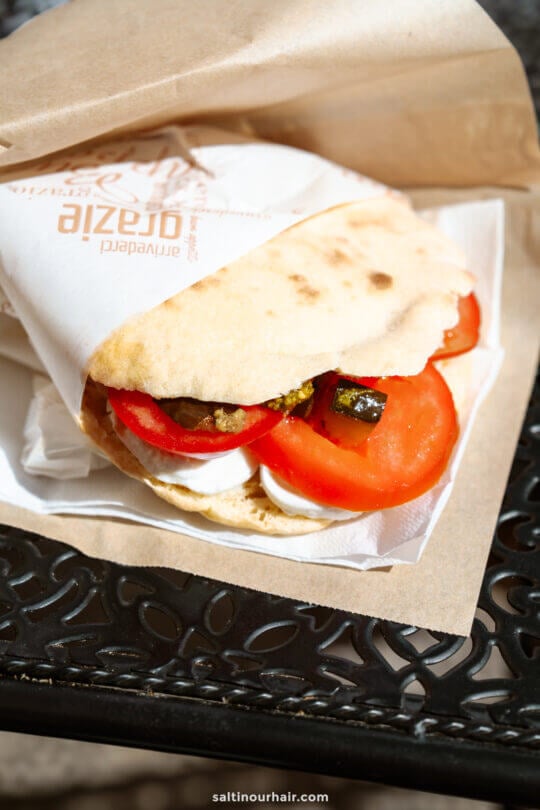 A pita sandwich filled with fresh tomato slices, mozzarella cheese, and grilled vegetables - what to eat in matera, italy