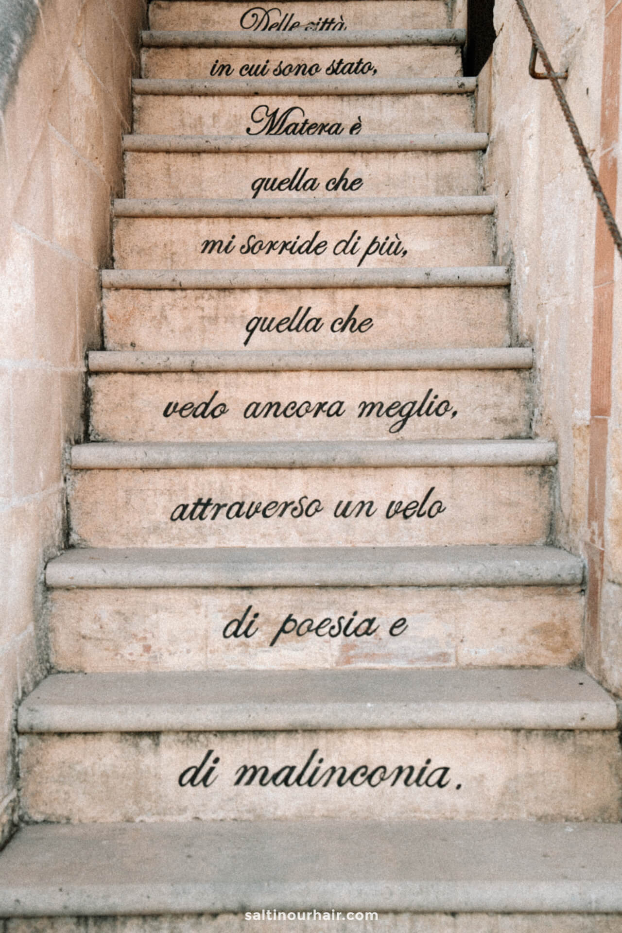 Stone staircase in Matera, Italy, with an Italian quote written on the risers