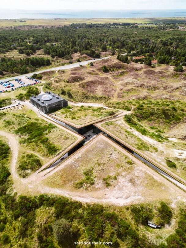 Aerial view of the star-shaped Tirpitz Museum surrounded by grassy landscape, with a building at the center and paths leading to the structure; a perfect stop for your Denmark itinerary