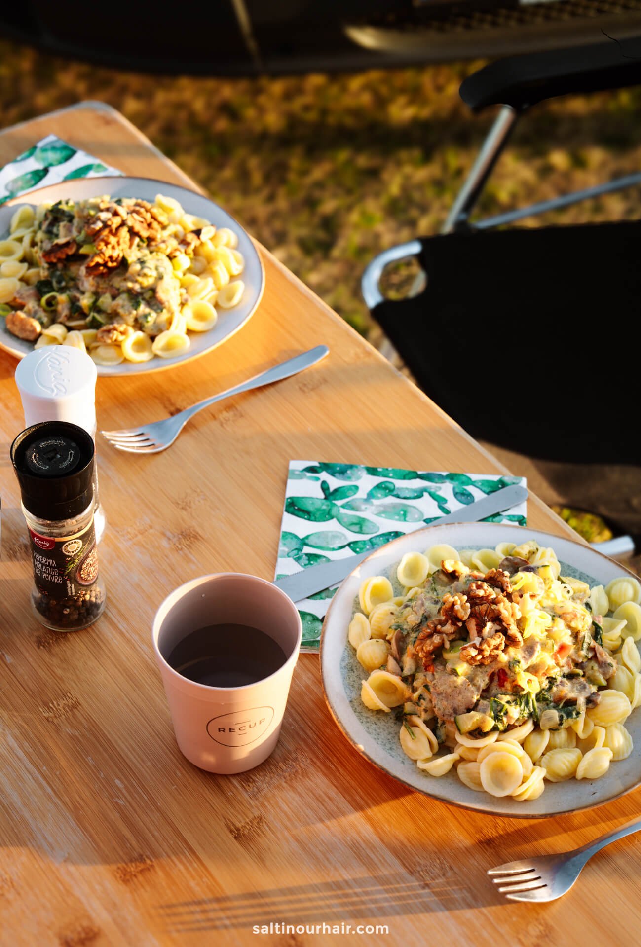 Plates of pasta and a cup of water on a table—perfect for fueling up before mapping out your Denmark itinerary.