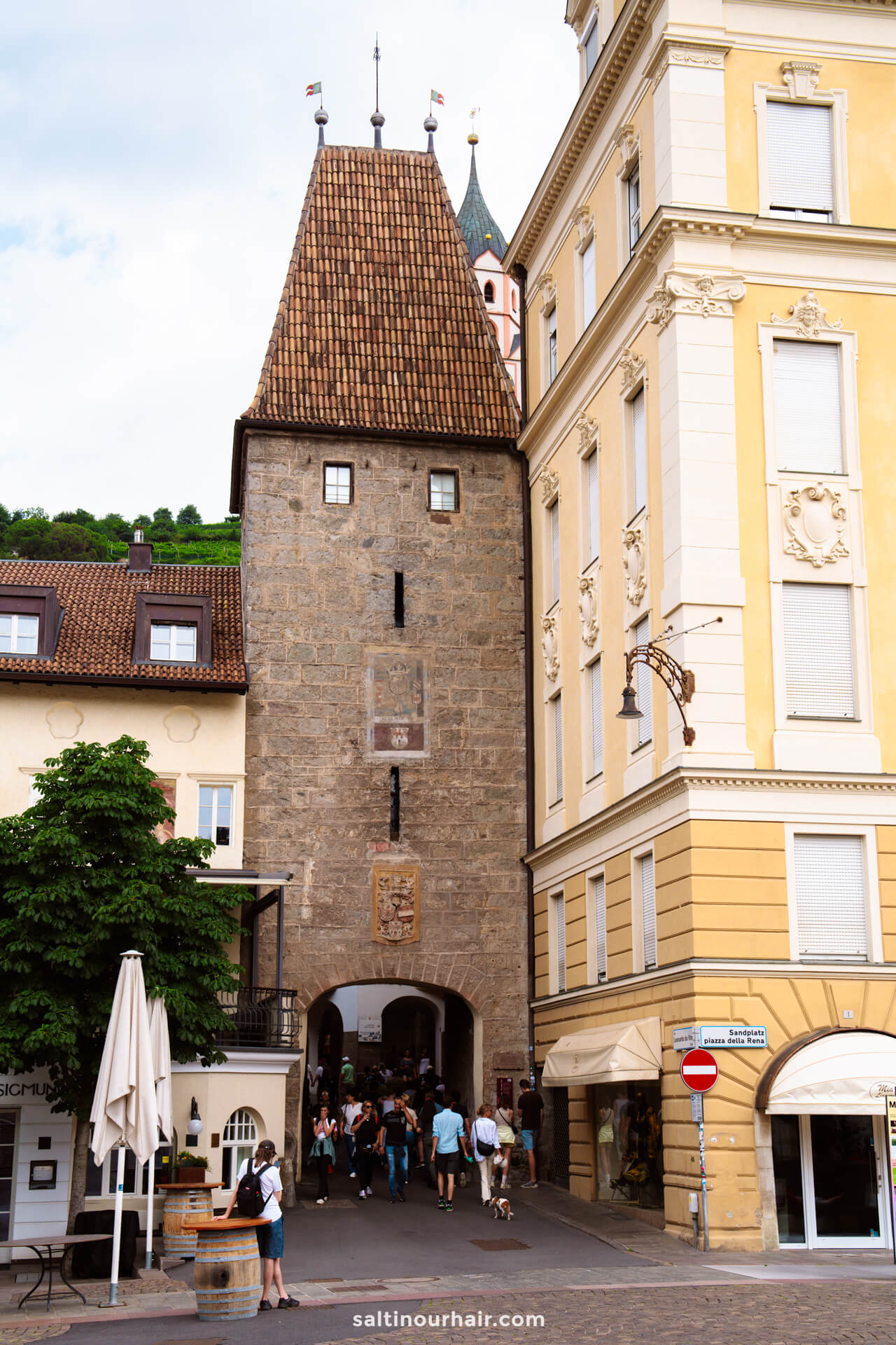 Old town of merano dolomites italy with a historic stone gate tower and yellow and white buildings